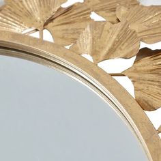 a mirror that has some gold leaves on it