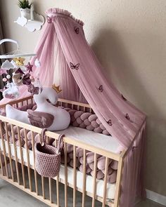 a baby crib with pink bedding and decorations