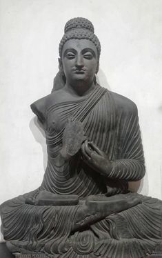 a statue of buddha holding a bird in his hands