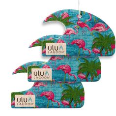 three pink flamingos hanging from hooks on a blue background with the words luu lagoon