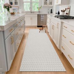 a kitchen with white cabinets and wooden floors