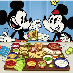 two mickey mouses sitting at a table with food