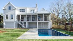 a large white house with a pool in the yard