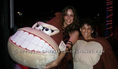 two women in costumes posing for a photo with a giant stuffed animal at a halloween party