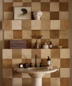 a bathroom sink sitting under a mirror next to a shelf filled with bottles and soaps