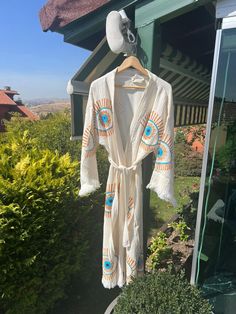 "Beautiful handmade white evil eye kimono robe or/and towel, sarong designed with cotton fabric, it flows as you move for comfortable wear. Beach cover-up, a kimono with an evil eye design.   This is a lovely, good-quality kimono, with traditional breathable kimono sleeves.        A belt that ties around the waist. Great to wear around the house, on beaches, or to dress up with some jeans & a T-shirt, covering up on the beach with a swimsuit.   Please choose a kimono, sarong, or set options depends what you would like to have :)      We love kimonos as they are so versatile. They also make really special & unique birthday, valentines Day, Christmas gifts, and Mother's Day gifts. The perfect combination of comfort and style, this kimono is a great addition to your new season wardrobe.    Co White Hippie Kimono For Spring, Long Beige Kimono For Festival, Beige Long Kimono For Festival, White Open Front Kimono For Festival, White Open Front Bohemian Kaftan, White Bohemian Kimono For Festival, White Bohemian Robe With Kimono Sleeves, White Wrap Kimono For Festival, Traditional White Robe With Kimono Sleeves