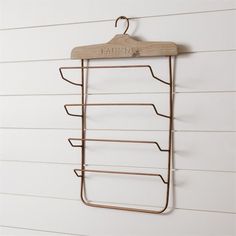 a coat rack hanging on the side of a white wall with a wooden hanger