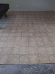 an empty room with a pool table in the middle and tile flooring on the other side