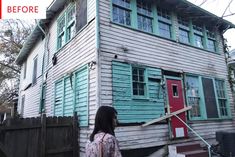 a woman standing in front of a house that has been gutted with wood and paint