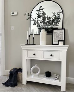 a white table with a mirror and some candles