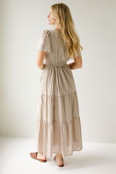 The 'Athena' dress is the perfect feminine staple to add to your closet! Easily transitioned throughout the year, the dress comes in a neutral taupe color, or a pretty merlot shade. The dress features flutter sleeves, an elastic waistband, tiered skirt, and dainty embroidered details on the front! 60% Cotton, 40% Polyester Shell 100% Polyester Lining Fully Lined Hand Wash Cold Hang or Lay Flat to Dry Do Not Bleach Low Iron If Needed Model in Merlot Height 5'9" | Wearing Size Small Model in Taupe Modest Beige V-neck Dress, Modest Beige Maxi Dress, Beige Fitted Modest Dress, Beige Spring Dress With Natural Waistline, Spring Beige Dress With Natural Waistline, Modest Beige Dress For Daywear, Taupe V-neck Spring Dress, Spring V-neck Taupe Dress, Spring Taupe V-neck Dress