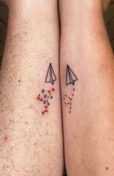 two people with tattoos on their legs, one has a paper airplane and the other has stars