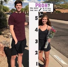 a young man and woman standing next to a sign that says prom you must be married this tall to say no