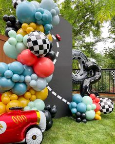 balloons are arranged in the shape of cars and race cars on display at a car themed birthday party