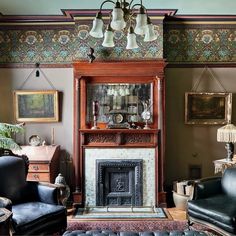 a living room filled with furniture and a fire place under a chandelier above a fireplace