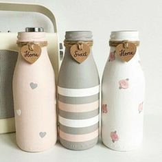 three bottles with hearts on them sitting next to a toaster