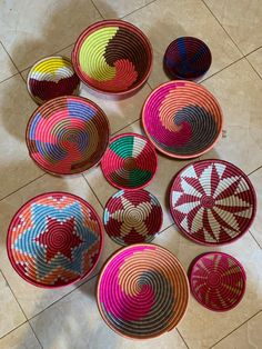 colorful baskets are arranged on the floor in rows, all with different designs and colors