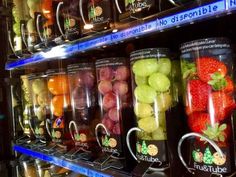 a display case filled with lots of different types of fruit in cups on top of each other