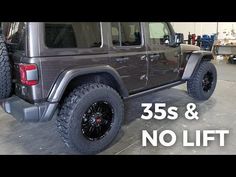 a black jeep parked in a garage with the words 35s and no lift on it