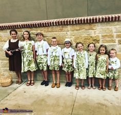 a group of young children standing next to each other in front of a brick wall