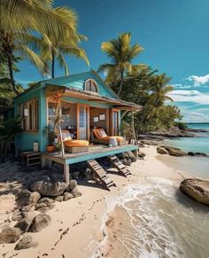 a small blue house on the beach with palm trees