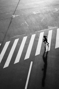 a person is walking across the street with an umbrella