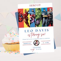 a birthday card with an image of superheros on it next to a cupcake