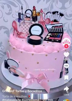 a pink cake with various items on it