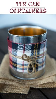 an empty tin can sitting on top of a cloth covered tablecloth with a string tied to it