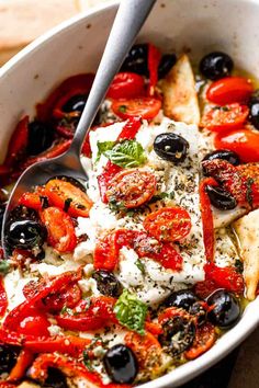 a white bowl filled with lots of different types of food on top of a table