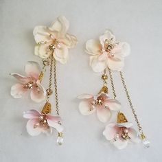 I created these Romantic Cherry Blossom Silk Flower Earrings especially for this special bride on her wedding day. It was so well received by her and admired by her guests that I decided to make more of these and offer to other brides to be. I used silk cherry blossoms and added fresh water pearls in the center of each flower. Hanging from the main flower are two other slightly opened flowers on gold chain on top of which is a gold crystal embellished bead. Another chain hangs and ends with crystal teardrops. They hang at the perfect length of 5 inches and look beautiful whether you leave your hair down or in an up do hair style.  These earrings are sure to add to the fairy tale romance of your special day. Length - 5 inches /12 cm Color: blush and ivory flowers, gold chain and wire, fresh Blossom Wedding, Flower Hanging, Cherry Blossom Wedding, Ivory Flowers, Fresh Water Pearls, Wedding Etsy, Fresh Water Pearl, Water Pearls, Silk Flower