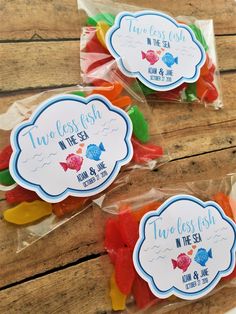 three bags filled with gummy bears sitting on top of a wooden table