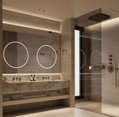 a bathroom with two sinks, mirrors and lights on the wall next to each other