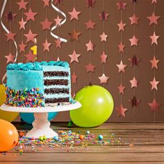 a birthday cake with blue frosting and sprinkles sits on a table