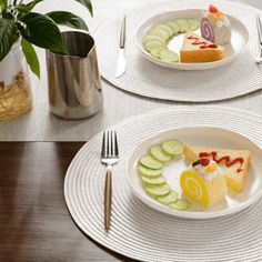 two white plates topped with slices of cake and cucumber slices on top of each plate