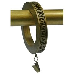 a brass ring with greek designs hanging from it's side