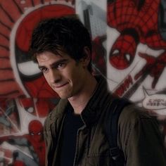 a man standing in front of a wall with spiderman artwork on it's walls