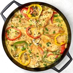 a skillet filled with chicken, peppers and mushrooms