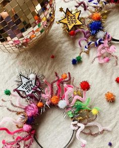 several colorful hair accessories are laying on the floor next to a disco ball and mirror