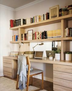 a desk with a laptop computer on top of it next to a bookshelf