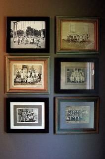 four framed pictures hang on the wall above a toilet