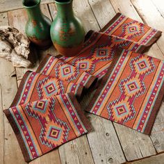 two green vases sitting on top of a wooden floor next to some rugs