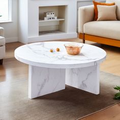 a white marble coffee table sitting on top of a hard wood floored living room