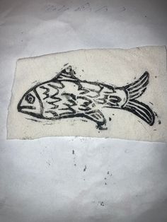 a drawing of a fish on a piece of white paper with black ink in it