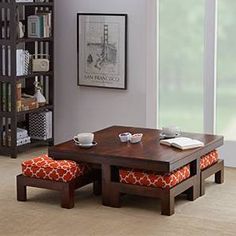 a coffee table with two stools in front of it and a bookcase behind it