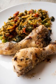 a white plate topped with chicken, broccoli and other food on top of it