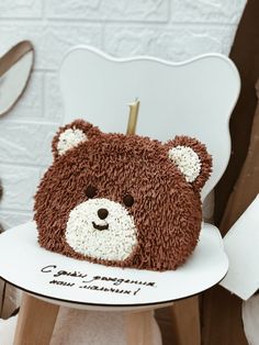 a brown teddy bear sitting on top of a white chair