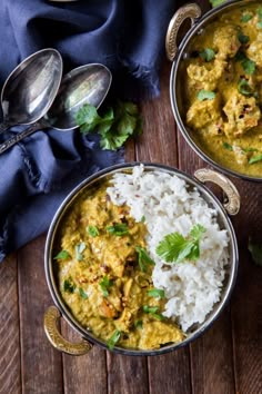 two silver bowls filled with rice and chicken curry