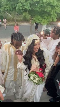 the bride and groom are surrounded by other people