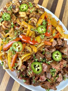 a white plate topped with meat and veggies on top of a wooden table